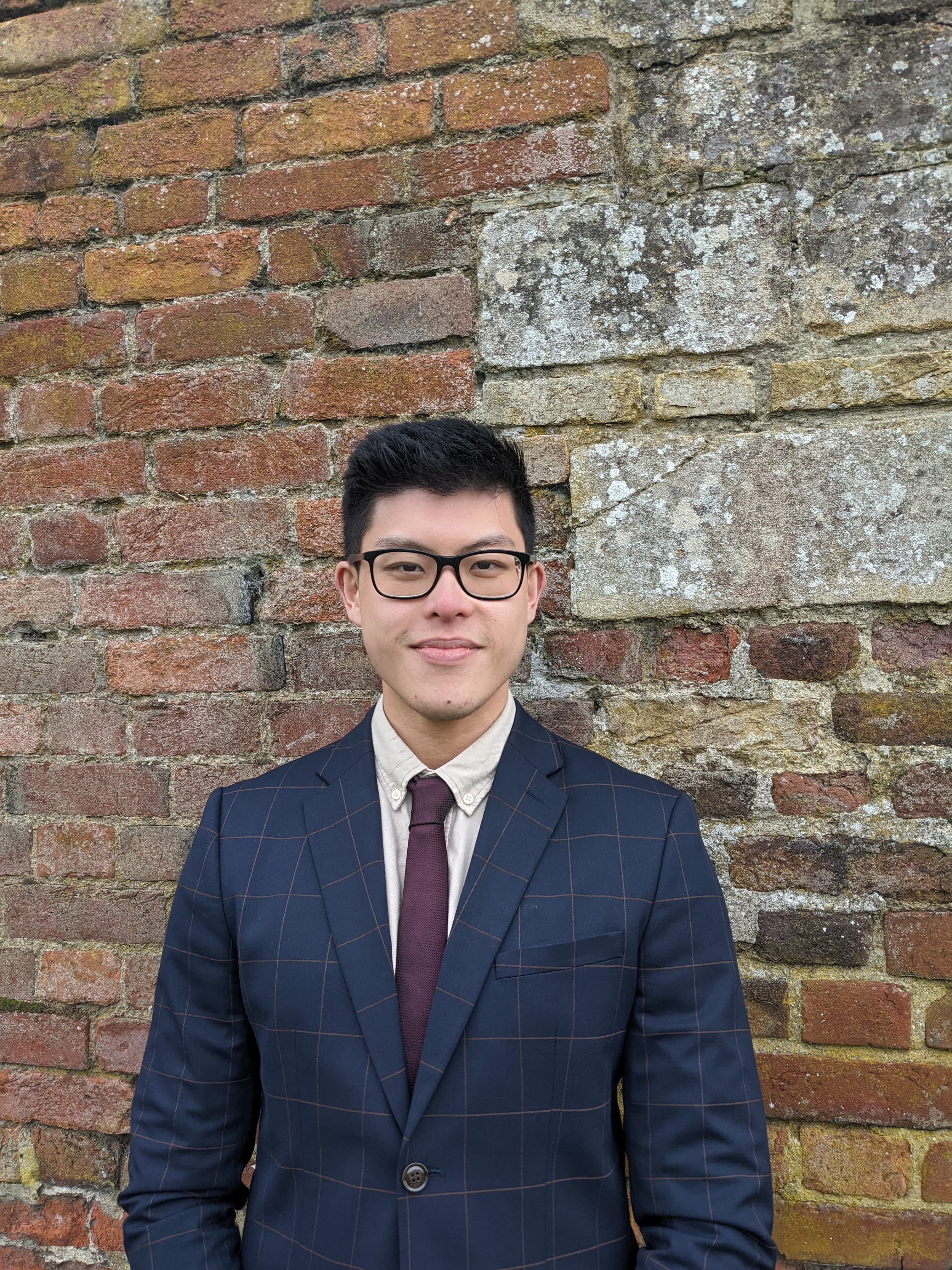 Jonathan, founder of johnnybuildstech, in front of a brick wall